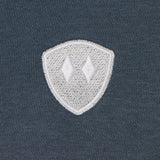detail of a washed denim hoodie embroidered with a gray and white double diamond shield