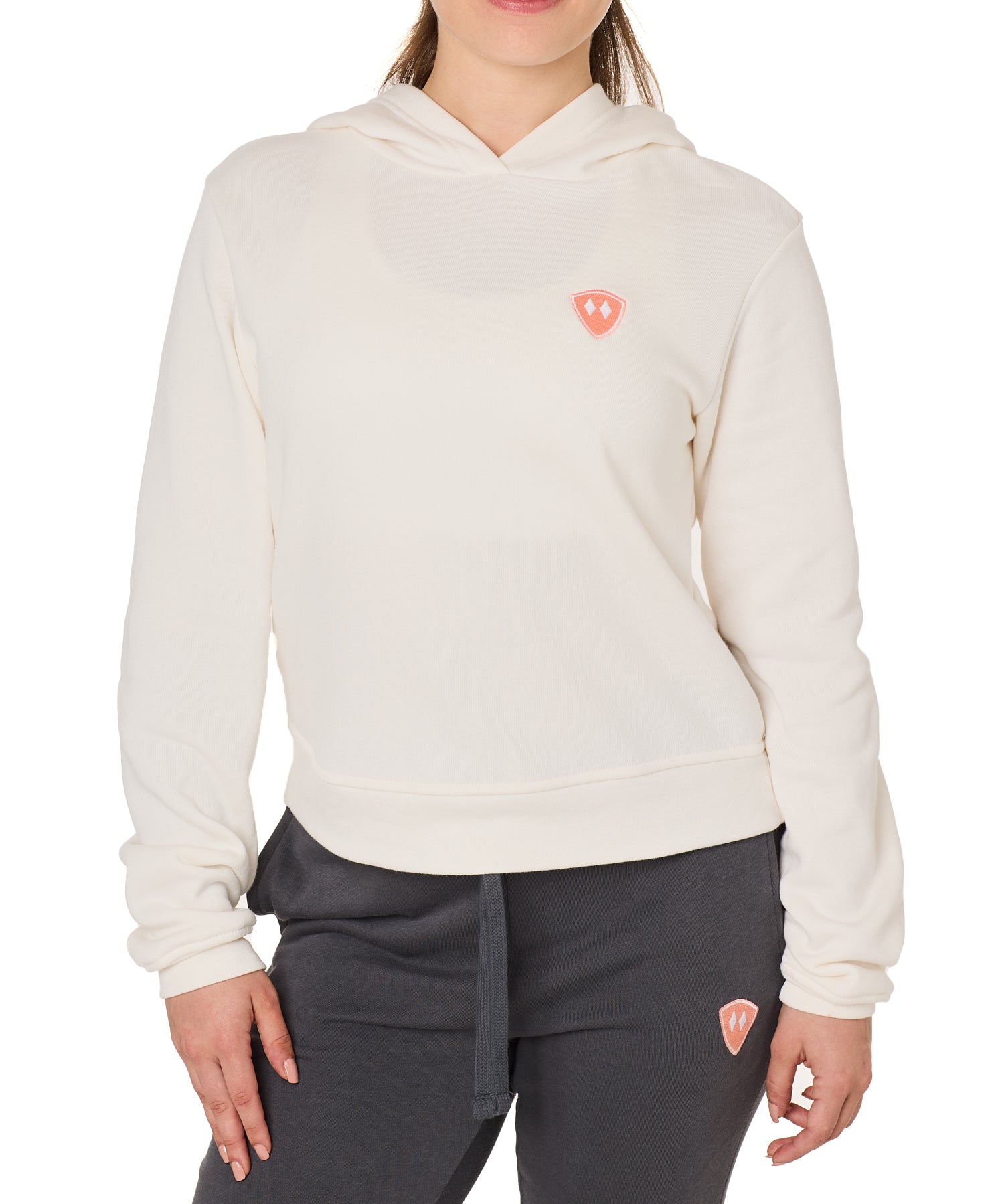 Front view of a female model wearing the vintage white Classic Hoodie on a white background, featuring a coral embroidered Double Diamond Shield on the wearer’s left chest.