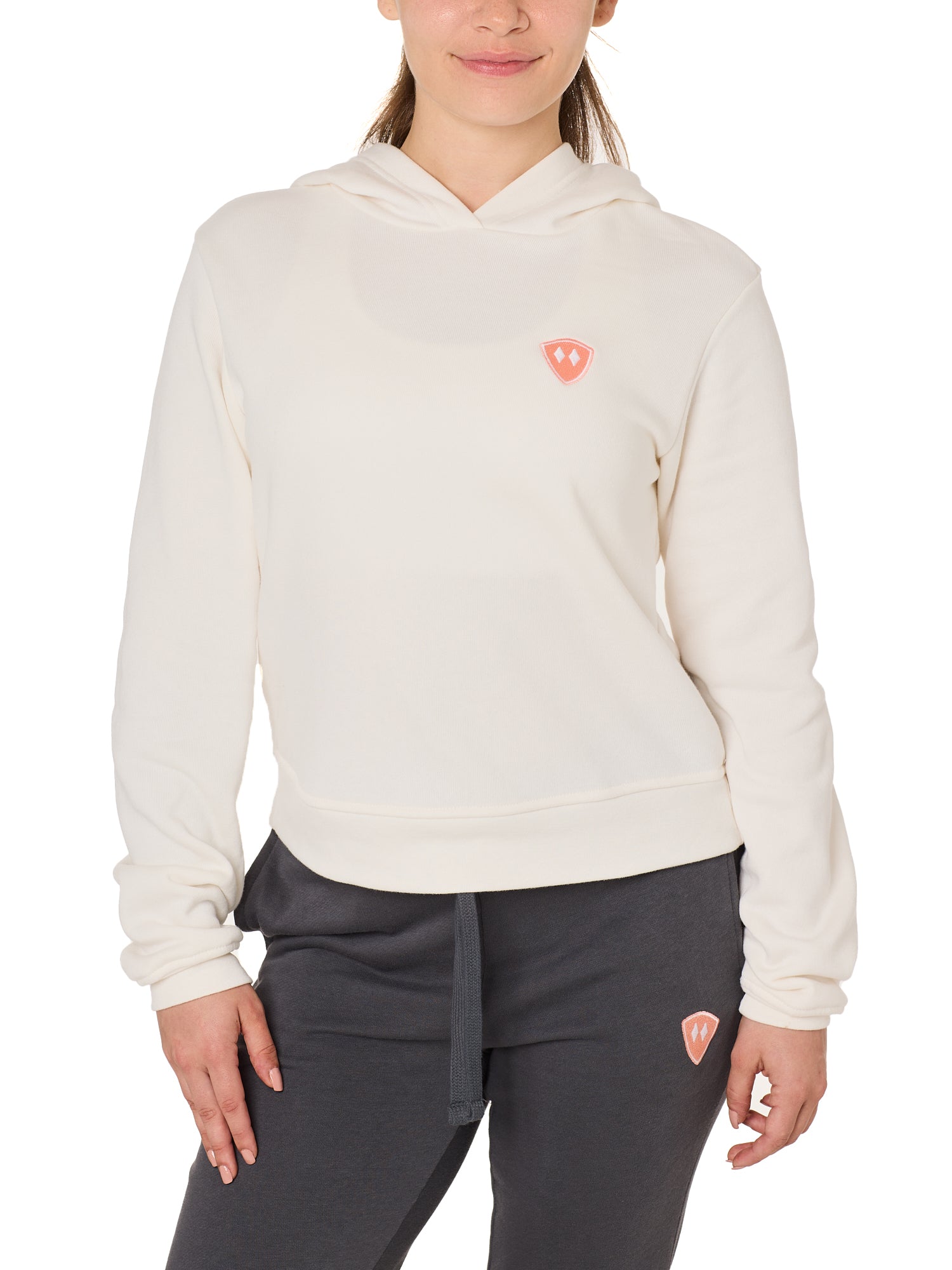Front view of a female model wearing the vintage white Classic Hoodie on a white background, featuring a coral embroidered Double Diamond Shield on the wearer’s left chest.