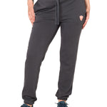 Front view of a female model wearing the women's summer night charcoal joggers. The joggers have a dyed to match drawstring and coral and white embroidered double diamond logo near the left pocket.