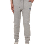 Front view of a male model wearing the Men's summer night heather gray joggers. The joggers have a dyed to match drawstring and navy and white embroidered double diamond logo near the left pocket.