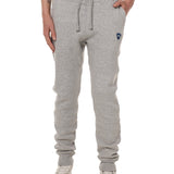 Front view of a male model wearing the Men's summer night heather gray joggers. The joggers have a dyed to match drawstring and navy and white embroidered double diamond logo near the left pocket.