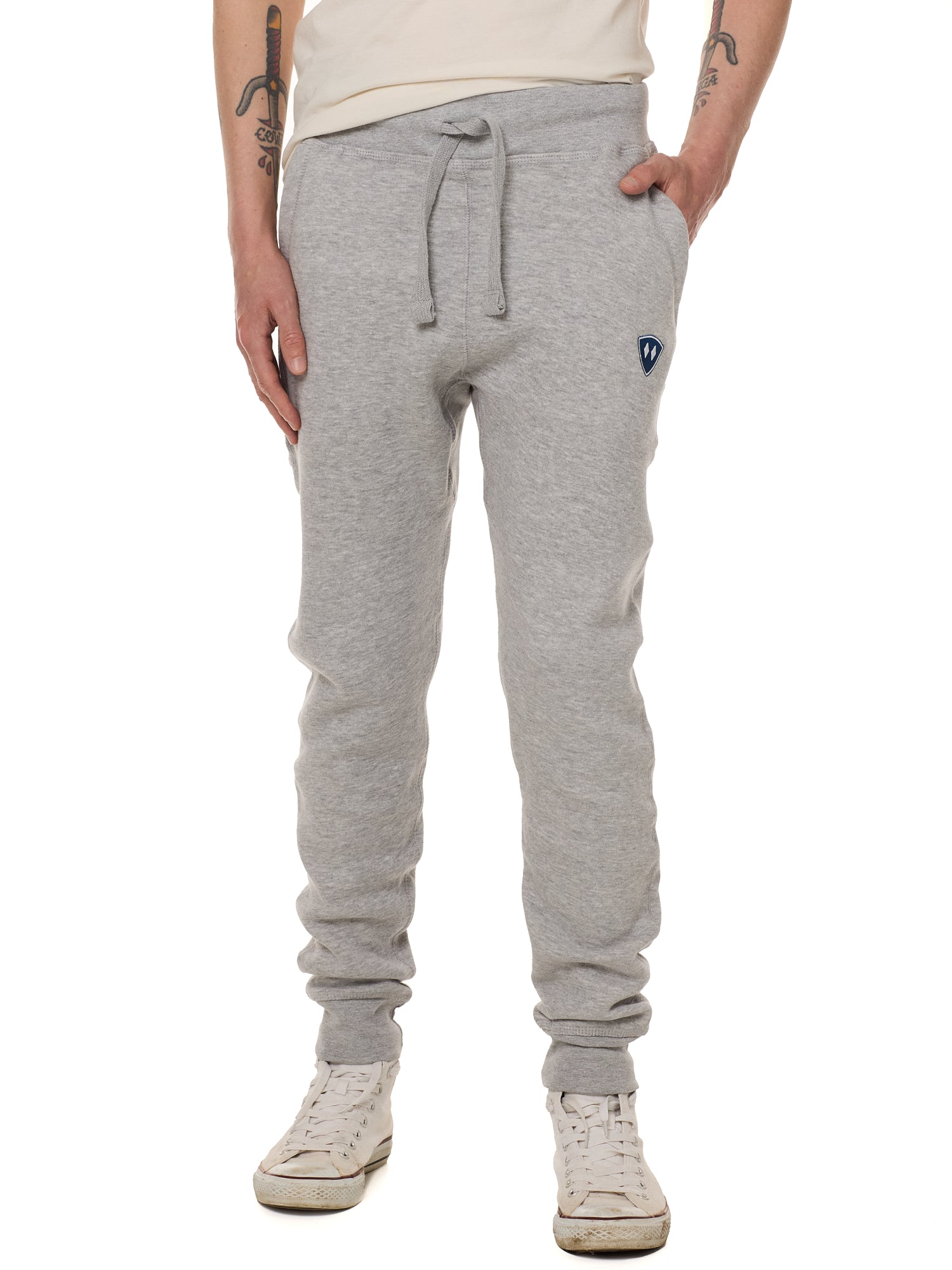Front view of a male model wearing the Men's summer night heather gray joggers. The joggers have a dyed to match drawstring and navy and white embroidered double diamond logo near the left pocket.