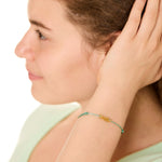 close up view of a female model wearing the copper fish bracelet