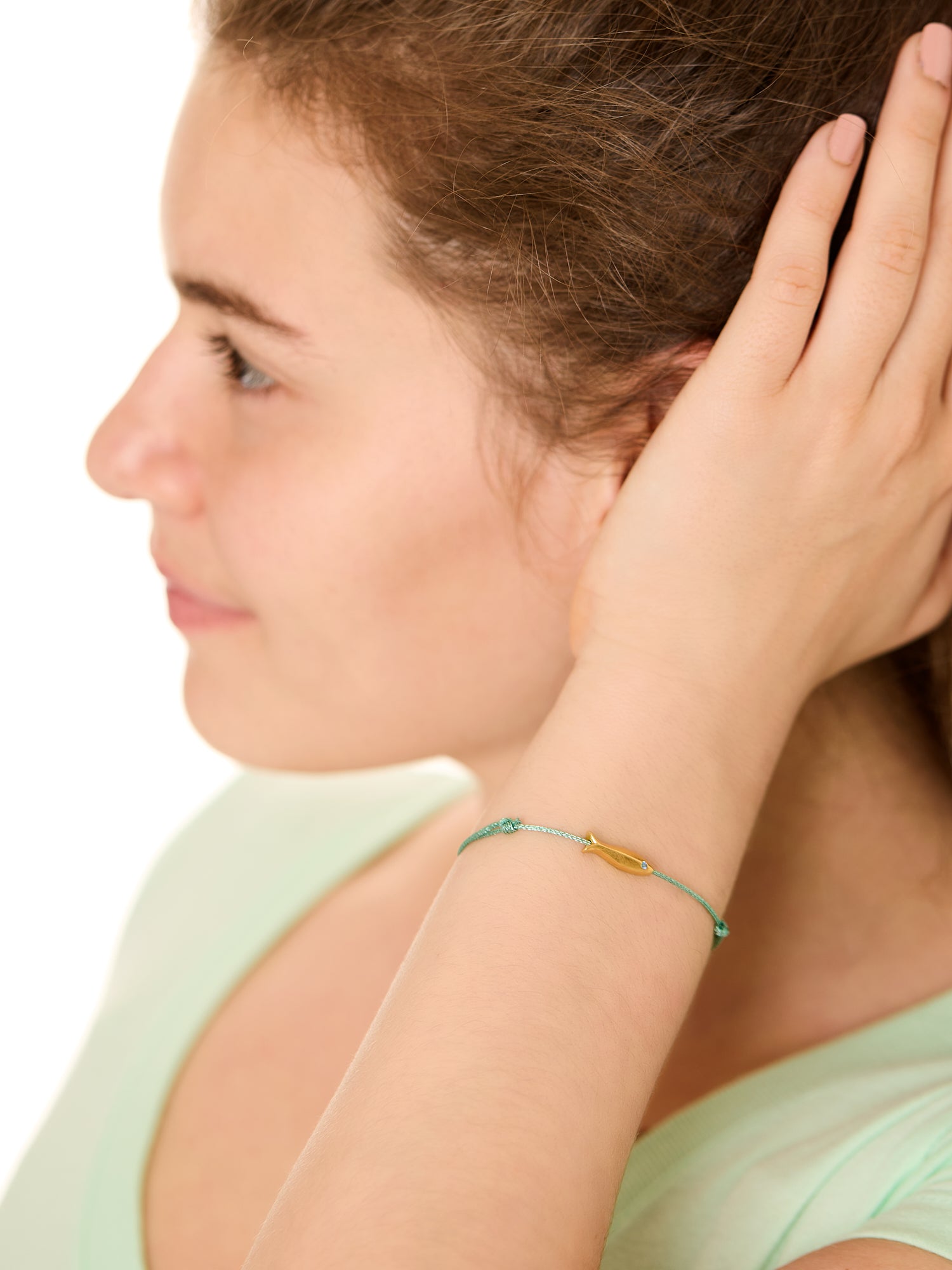 close up view of a female model wearing the copper fish bracelet