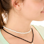 close up view of a female model wearing the black beachcombers necklace layered with the gray echoes of Atlantis necklace