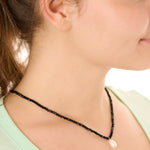 close up view of a female model wearing the black beachcombers necklace