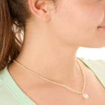 close up view of a female model wearing the cream beachcombers necklace