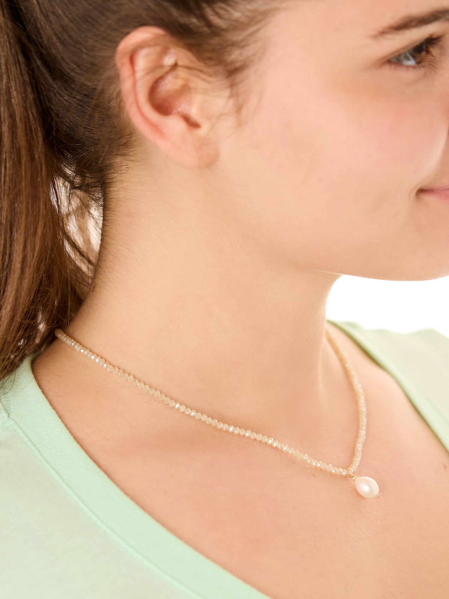close up view of a female model wearing the cream beachcombers necklace