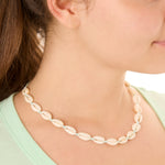 Close-up view of a female model wearing the turquoise Outer Banks Cowrie necklace 