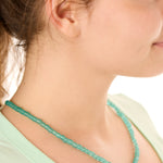 Close-up view of a female model wearing the green Echoes of Atlantis necklace 