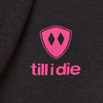 Detail of the hot pink till i die logo on a heather black hoodie