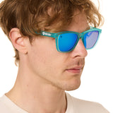 front view of a male model wearing the blue mirage sunglasses on a white background