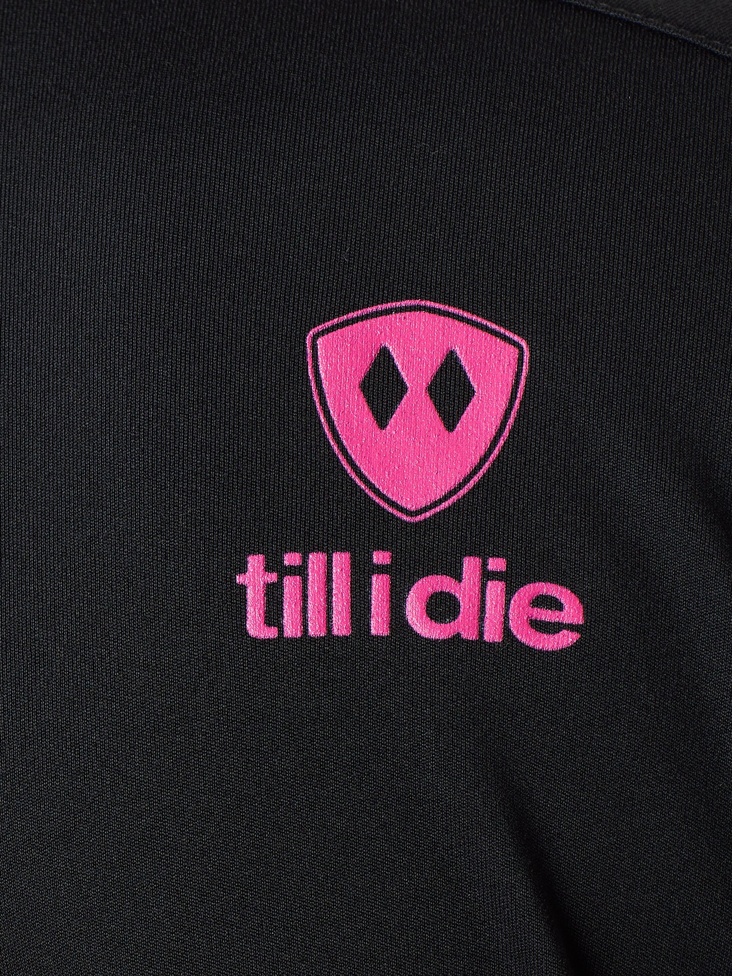 Detail of the hot pink till i die logo on a black performance long sleeve shirt