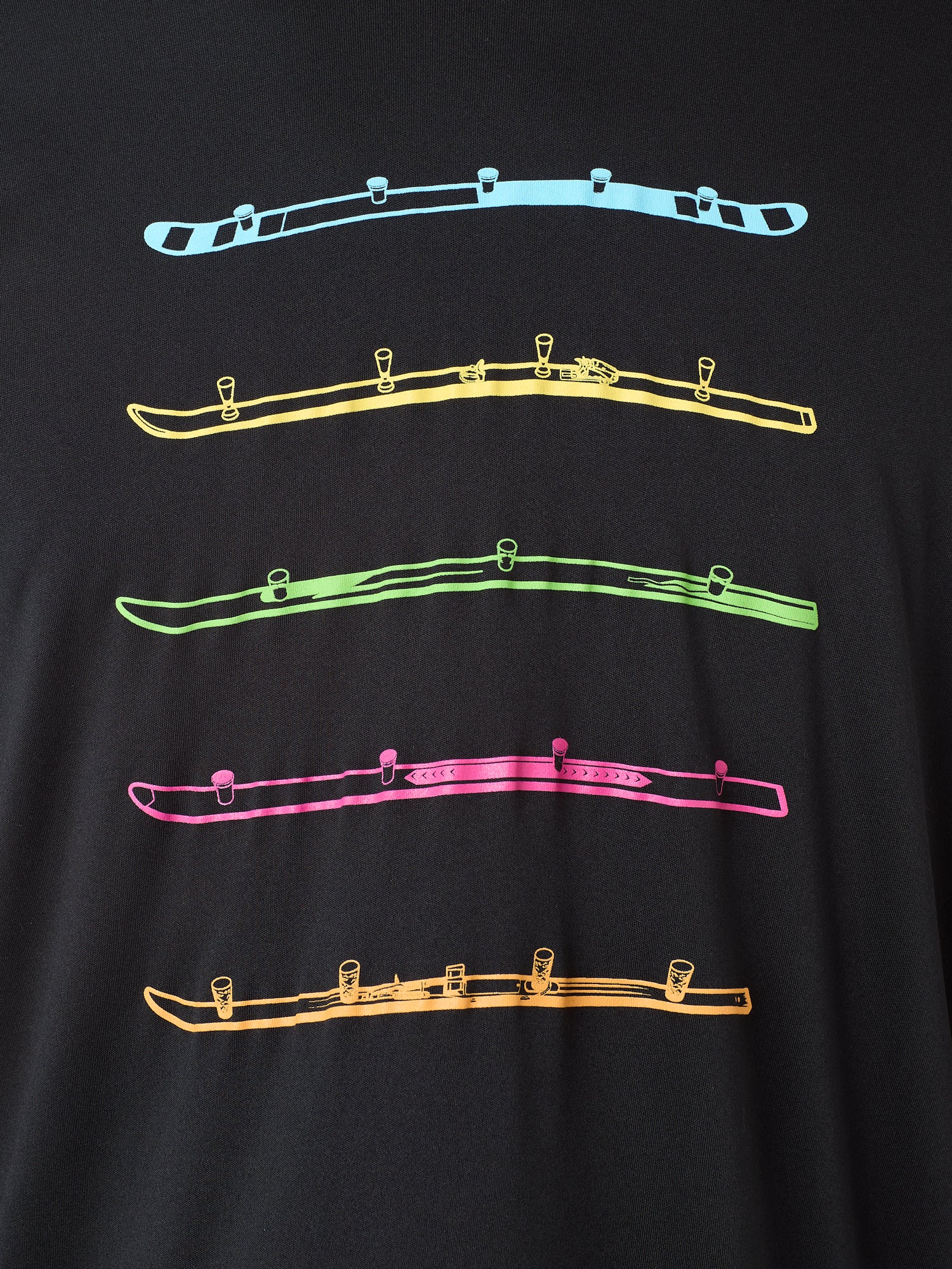 Detail view of the black Shot Ski performance long sleeve on a white background, featuring five multicolored shot skis illustrated in a line art style across the front.