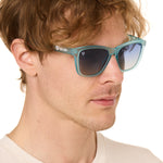 front view of a male model wearing the wave rider sunglasses on a white background