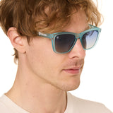 front view of a male model wearing the wave rider sunglasses on a white background