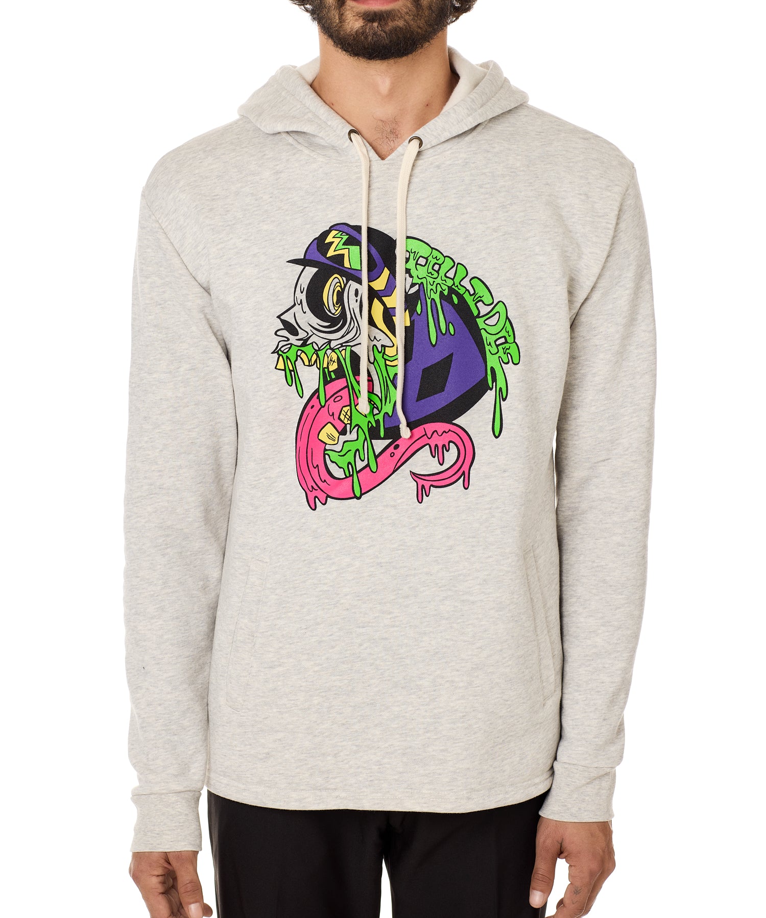 Front view of a male model wearing the Steezy Stan Hoodie in Heather Oatmeal on a white background. The graphic features a multicolored zombie skier with a long tongue, dripping slime, the Double Diamond Shield bursting from its skull, and oozing "Till I Die" text in a sludge-like style.