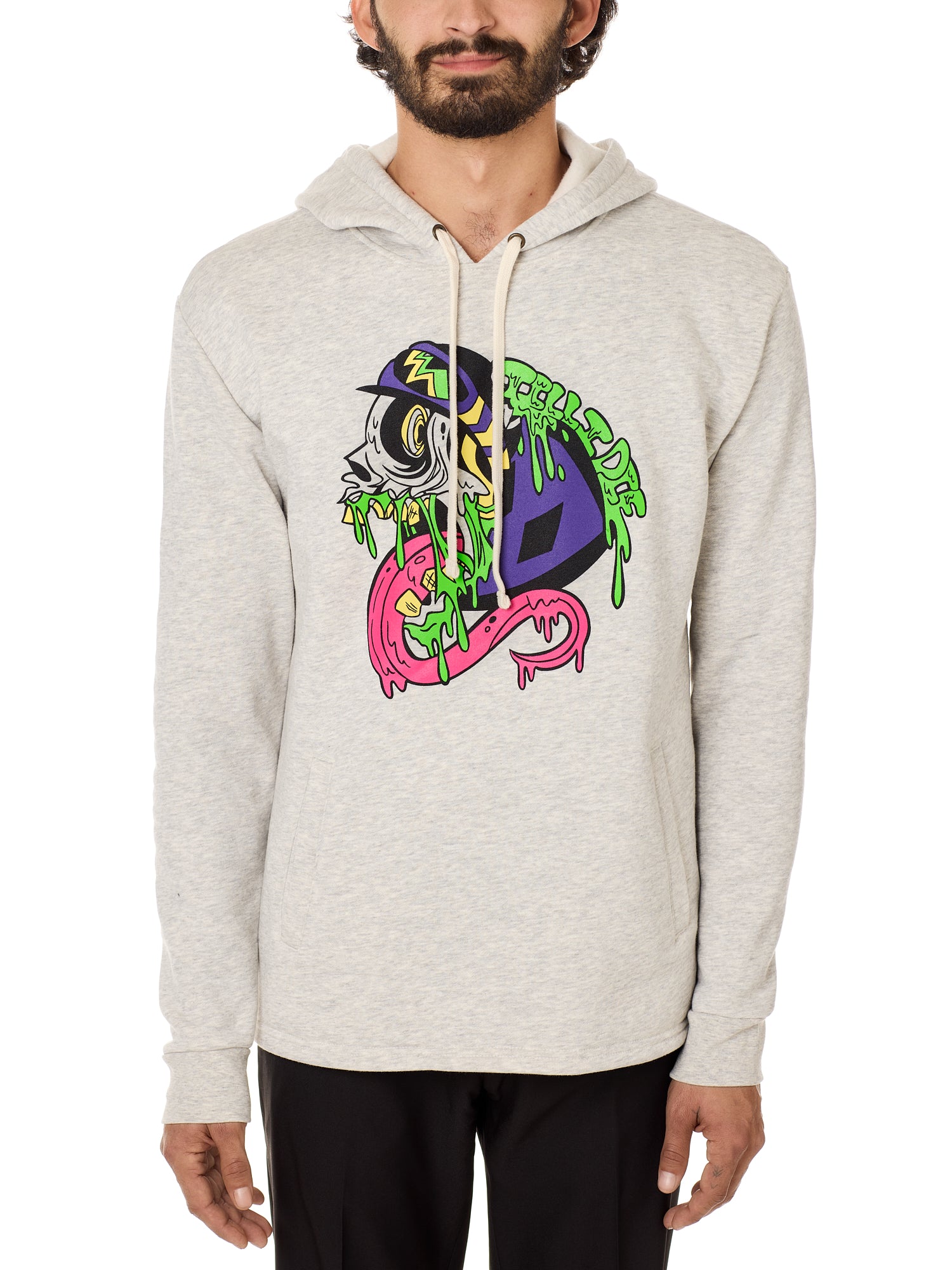 Front view of a male model wearing the Steezy Stan Hoodie in Heather Oatmeal on a white background. The graphic features a multicolored zombie skier with a long tongue, dripping slime, the Double Diamond Shield bursting from its skull, and oozing "Till I Die" text in a sludge-like style.