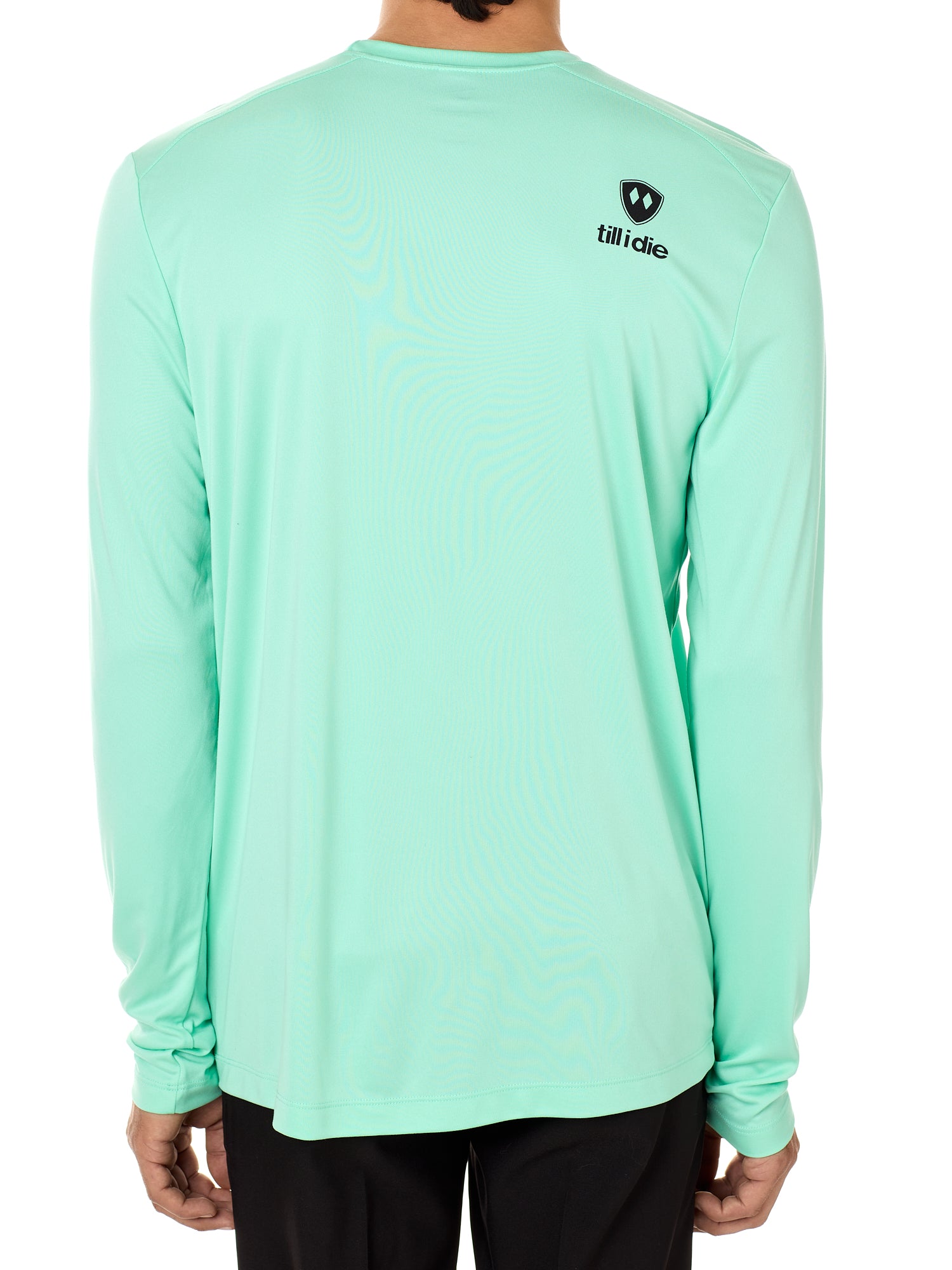 Back view of a male model wearing a mint green performance long sleeve shirt on a white background, featuring a black Till I Die logo on the wearer’s top right shoulder.