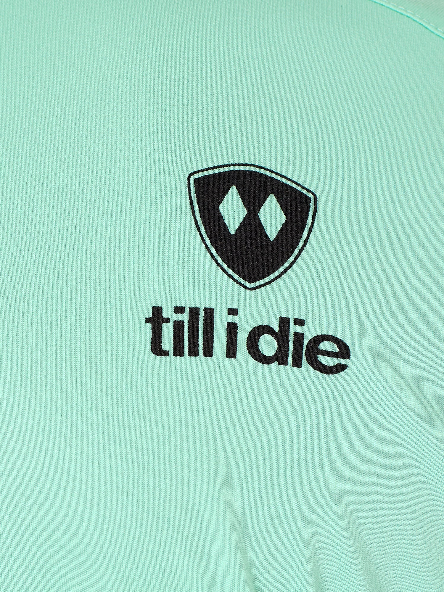 Detail of the black till i die logo on a mint green performance long sleeve shirt