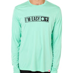 Front view of a male model wearing the "I'm Easy" Mint Green Long Sleeve Performance Shirt. The graphic features trail sign-inspired "I'm Easy" text with a circle symbol indicating beginner terrain.