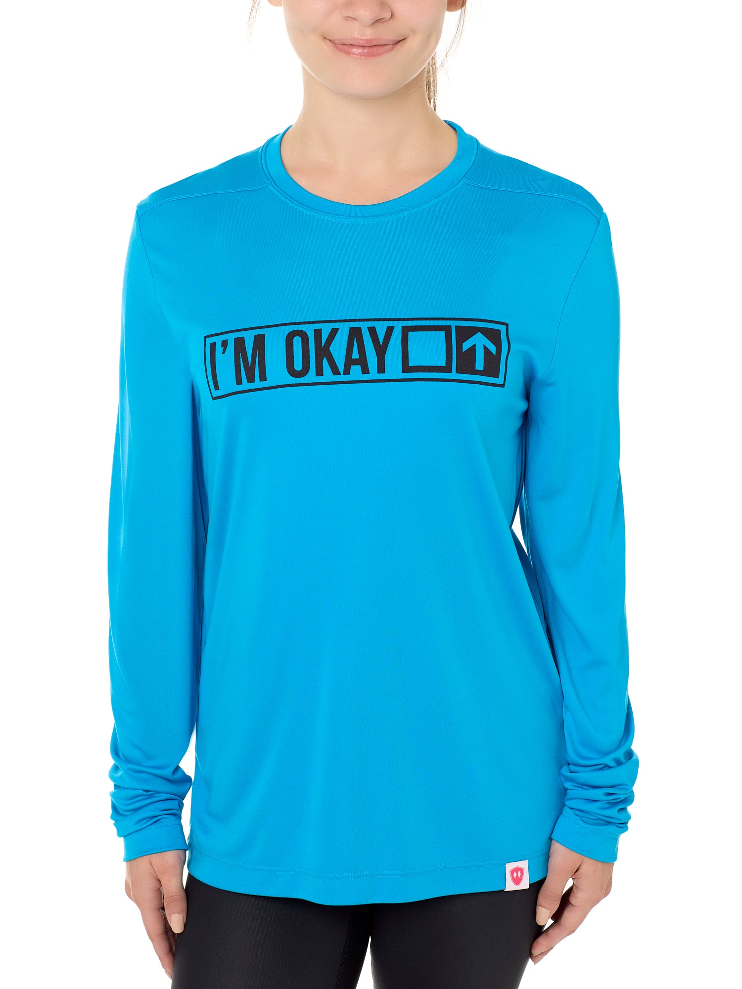 A female model wearing a blue long sleeve T-shirt with the text 'I'm Okay' IN A TRAIL SIGN DESIGN printed on the front.