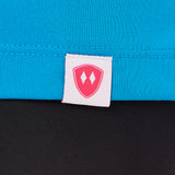 Close-up detail of a pink Double Diamond Shield woven hem label on a sapphire blue performance long sleeve shirt.