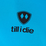 Detail of the black till i die logo on a Sapphire blue performance long sleeve shirt