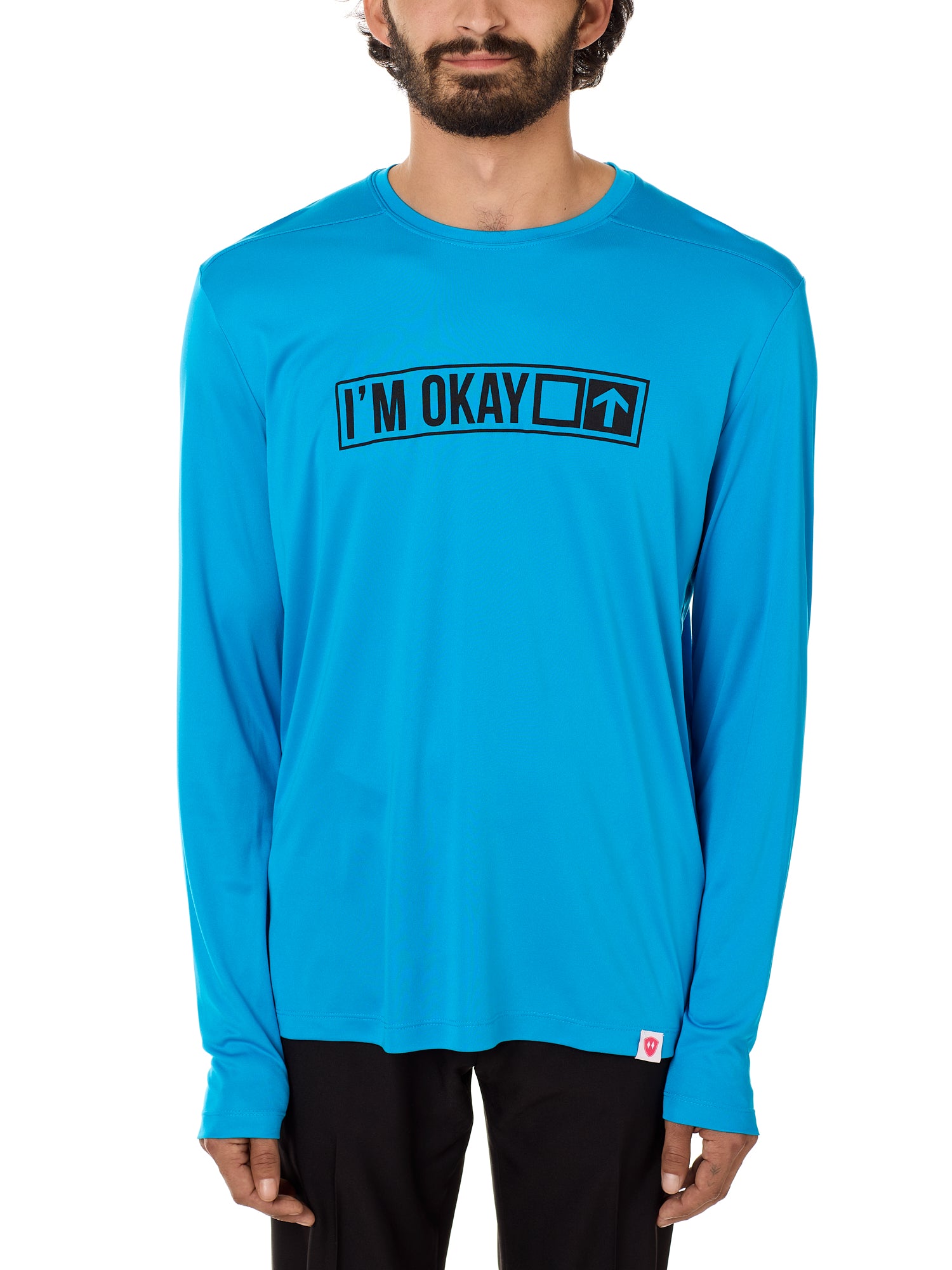 Front view of a male model wearing the "I'm Okay" Sapphire Long Sleeve Performance Shirt. The graphic features trail sign-inspired "I'm Okay" text with a square symbol indicating intermediate terrain.