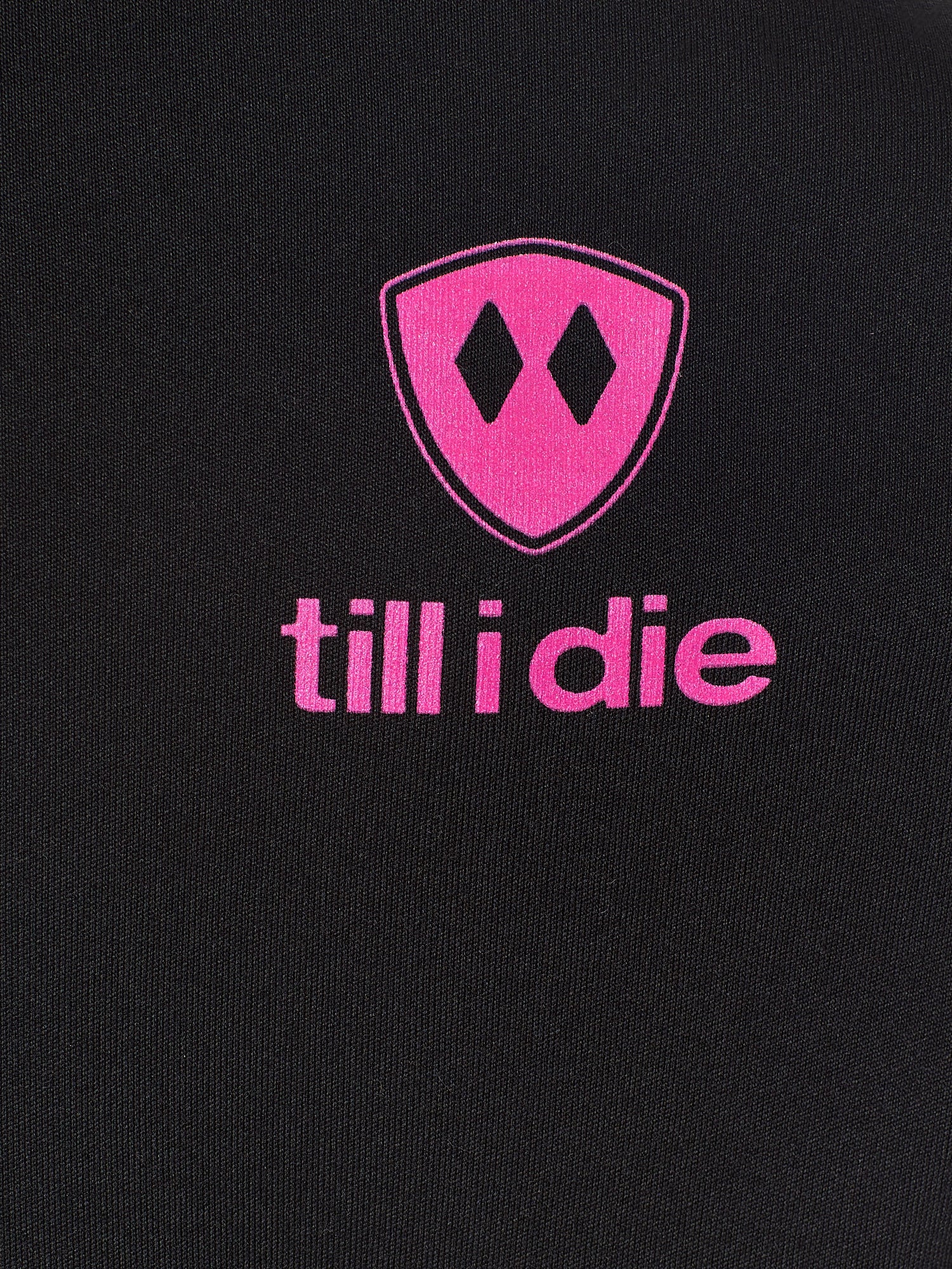 Detail of the hot pink till i die logo on a black performance long sleeve shirt