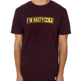Front view of a male model wearing the "I'm Nasty" Oxblood Tee Shirt. The graphic features trail sign-inspired "I'm Nasty" text with a double diamond symbol indicating expert terrain.