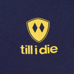 Detail of the yellow till i die logo on a navy tee shirt