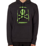 A male model wearing a black hoodie with a bold, green skull and crossbones design on the front.