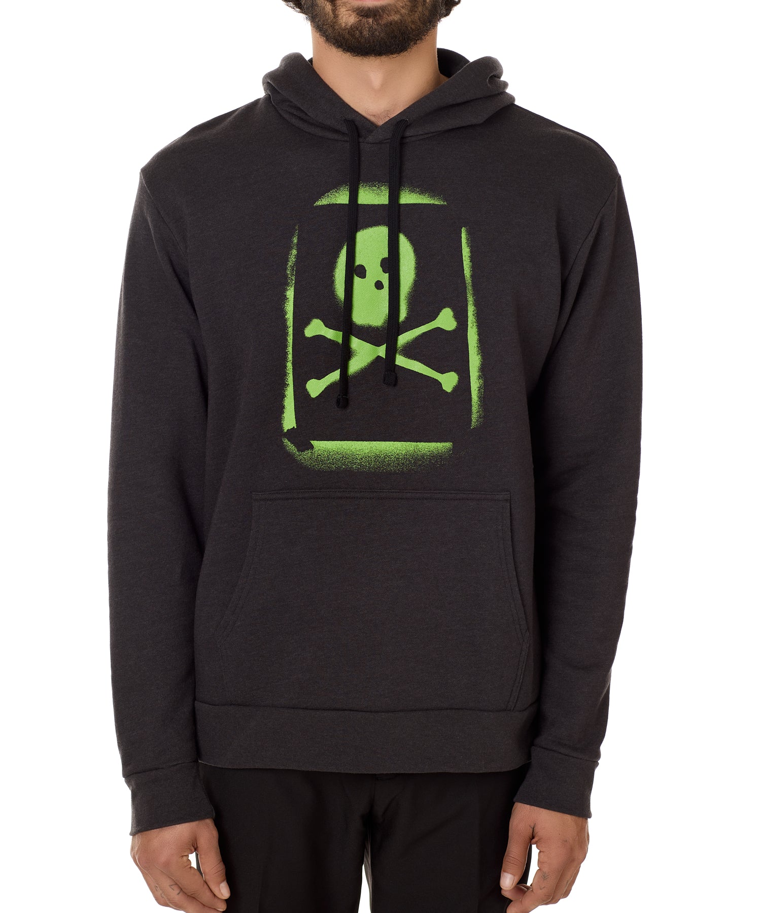A male model wearing a black hoodie with a bold, green skull and crossbones design on the front.
