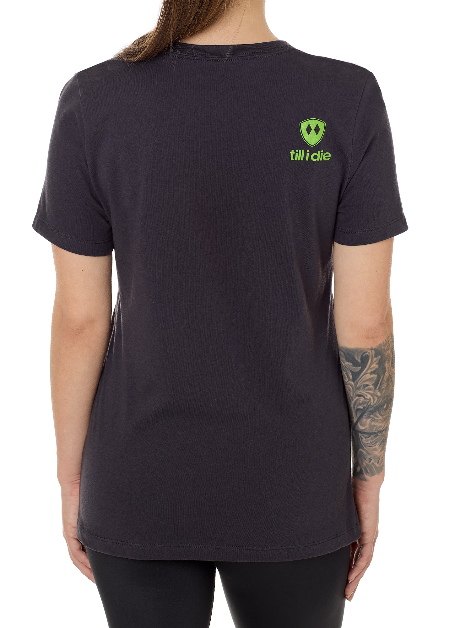 Back view of a female model wearing a dark gray tee shirt accented with a lime green till i die logo on wearers top right shoulder.