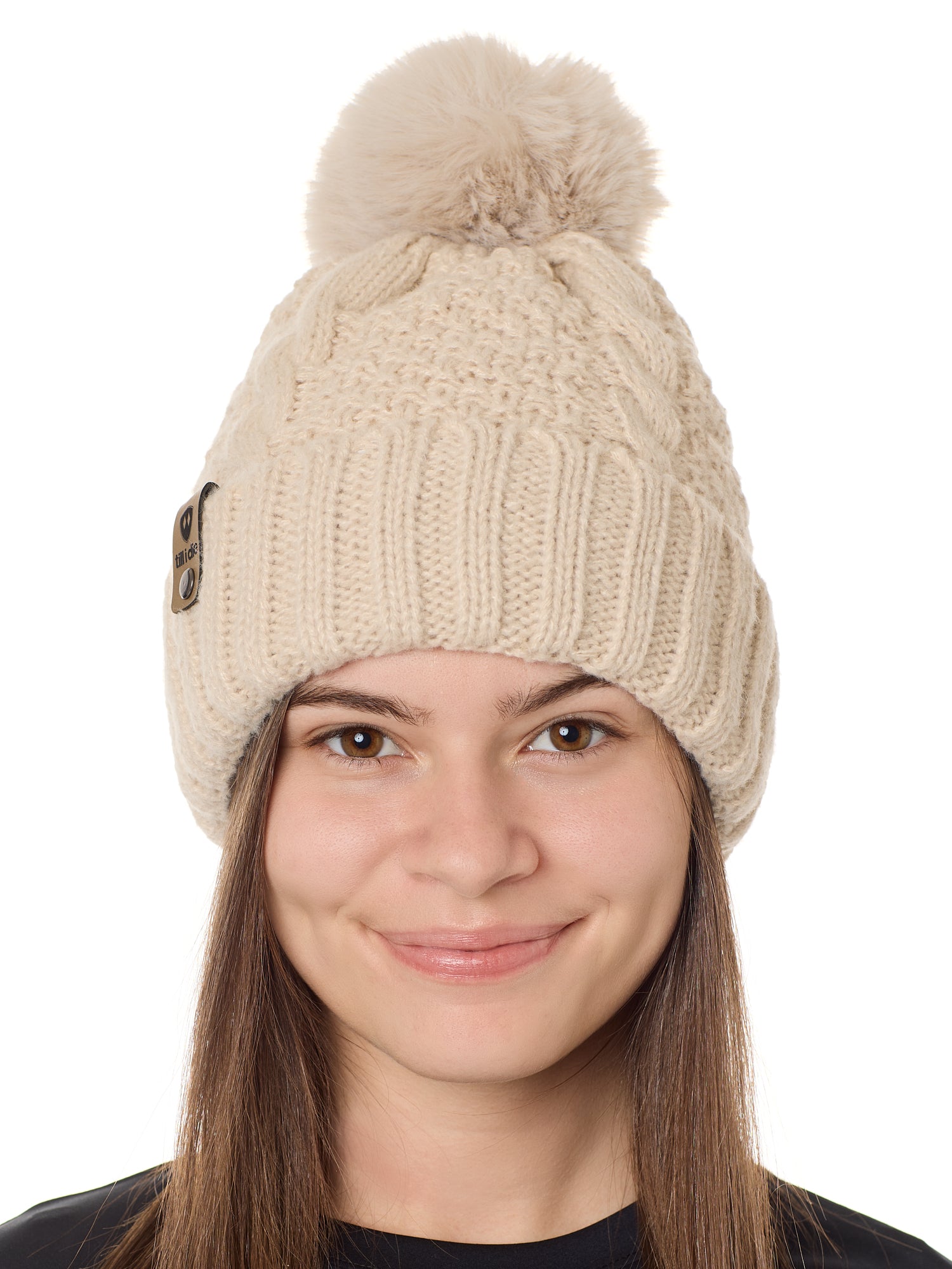 front view of a female model wearing a vintage white knit pom beanie featuring a matching pom pom, cuff and leather till i die logo tab with a nickel fastener.