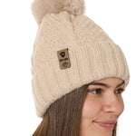 side view of a female model wearing a vintage white knit pom beanie featuring a matching pom pom, cuff and leather till i die logo tab with a nickel fastener.