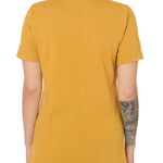 Back view of a female model wearing a mustard tee shirt on a white background