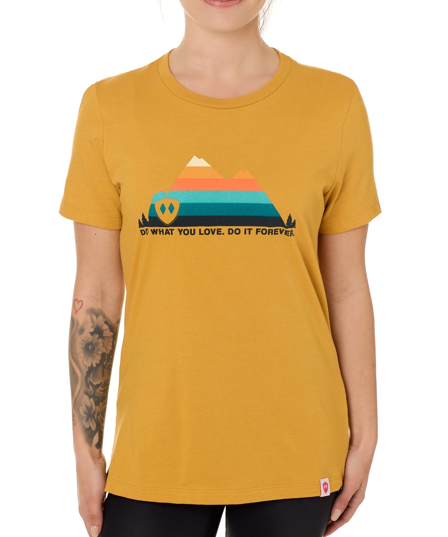 A female model wearing a mustard crew neck t-shirt with a mountain and sunset design and 'DO WHAT YOU LOVE. DO IT FORVER.' TEXT