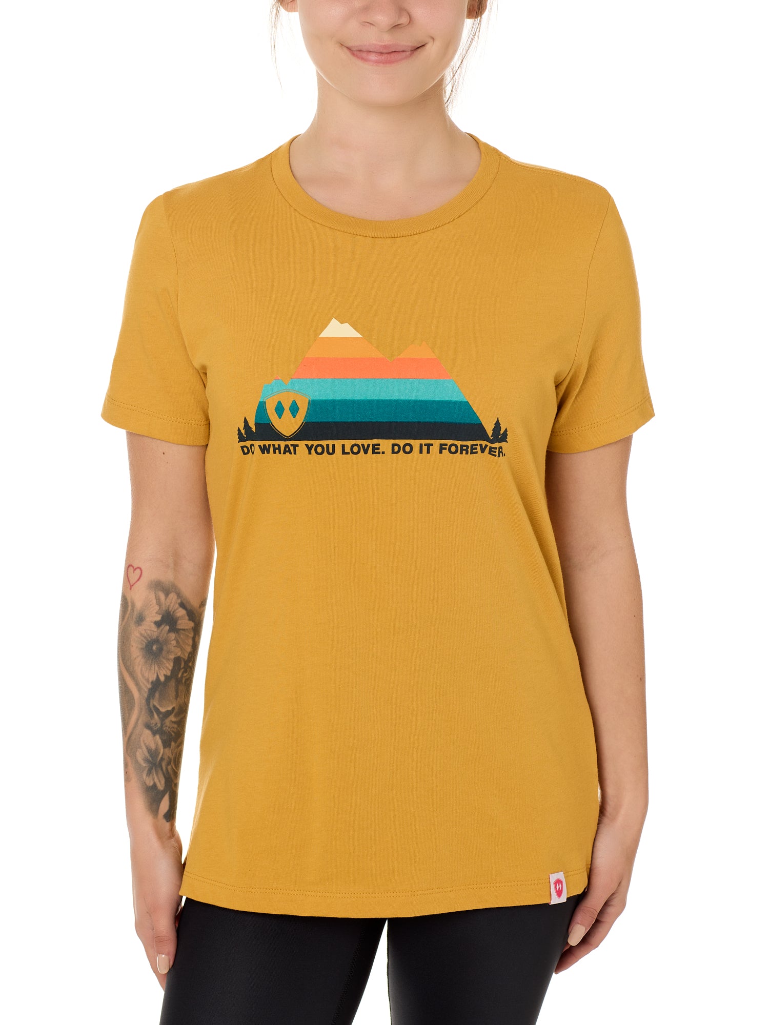 A female model wearing a mustard crew neck t-shirt with a mountain and sunset design and 'DO WHAT YOU LOVE. DO IT FORVER.' TEXT