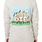 FEMALE MODEL WEARING A HEATHER OATMEAL HOODIE WITH HOOD UP, FEATURING A GRAPHIC OF A CARTOON MOUNTAIN THAT HAS TILL I DIE ACROSS IT