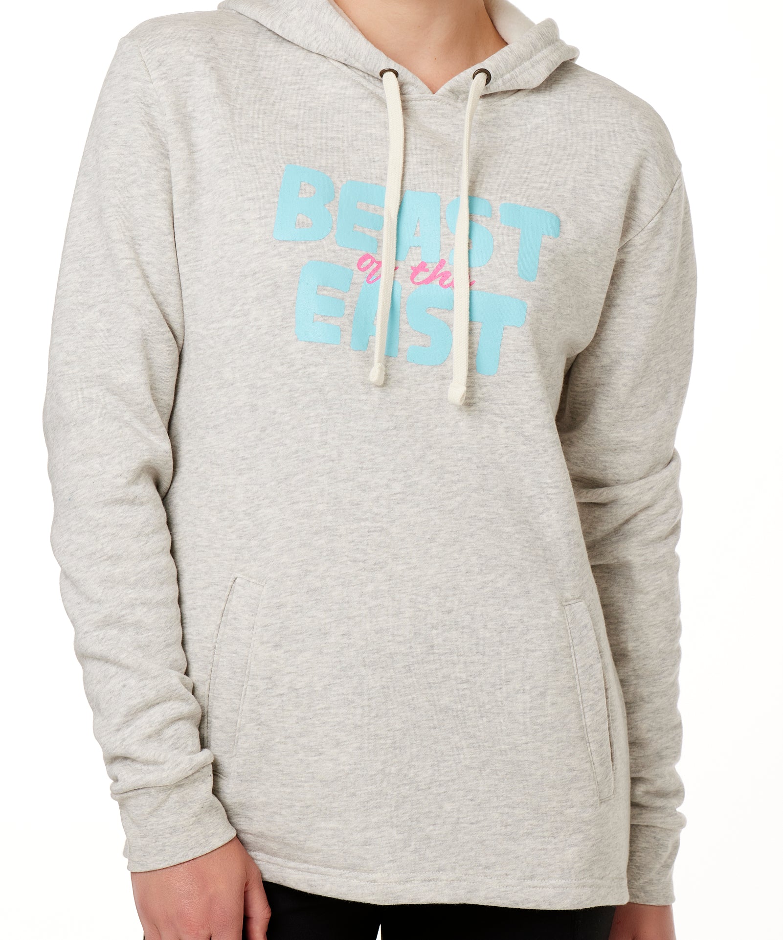 FEMALE MODEL WEARING A HEATHER OATMEAL HOODIE WITH A PINK AND BLUE GRAHIC THAT SAYS BEAST OF THE EAST