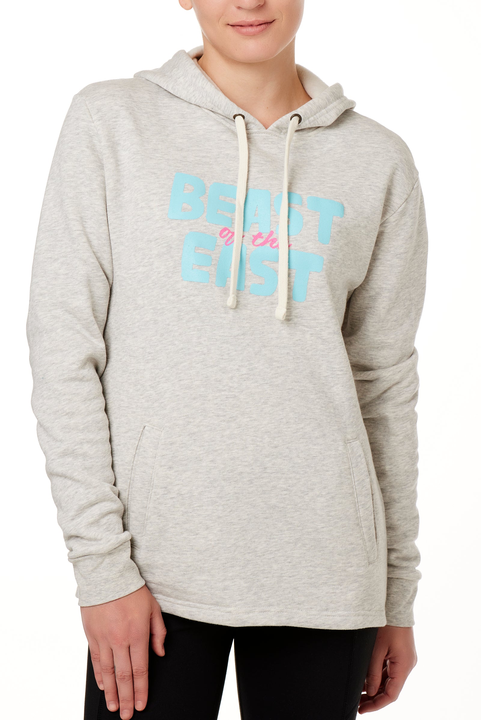 FEMALE MODEL WEARING A HEATHER OATMEAL HOODIE WITH A PINK AND BLUE GRAHIC THAT SAYS BEAST OF THE EAST
