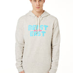 FEMALE MODEL WEARING A HEATHER OATMEAL HOODIE WITH A PINK AND BLUE GRAHIC THAT SAYS BEAST OF THE EAST