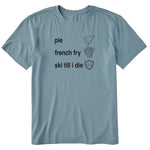 Blue T-shirt featuring black text and hand-drawn icons celebrating three mountain essentials: pie, French fries, and “Ski Till I Die,” finished with the signature Double Diamond shield.