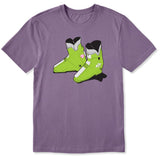 A dusty purple short-sleeve crewneck t-shirt featuring a graphic print of a pair of lime green retro rear entry ski boots with white, black, and pink details.