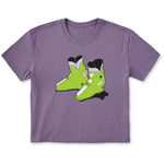 A purple short-sleeve crewneck t-shirt featuring a graphic print of two lime green rear entry ski boots in the center, displayed on a clean white background.