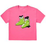 A bright pink short-sleeve t-shirt featuring a graphic print of lime green retro rear entry ski boots with black and white details on the front chest, displayed against a solid white background.