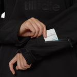 Close-up of left sleeve lift-pass pocket being opened with RFID ski pass partially revealed.